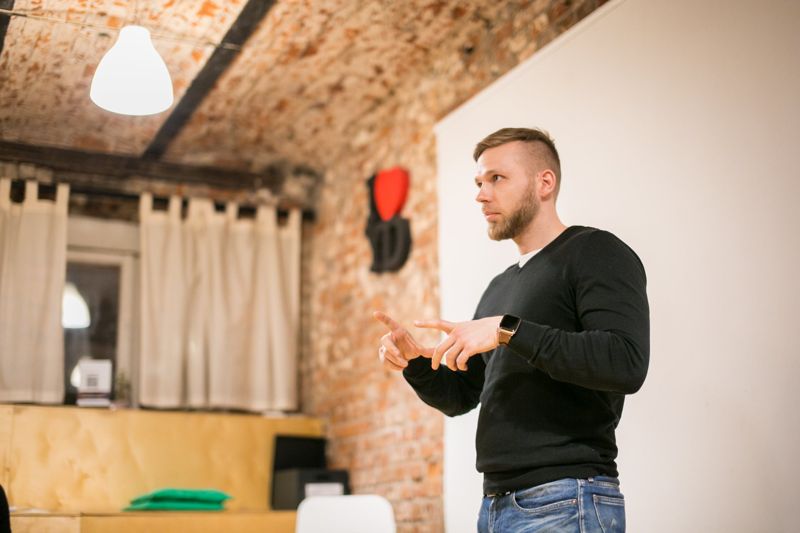 A founder in a black jumper presenting under a brick vault